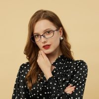 一位戴细框眼镜的编辑侧身坐在工位前，手指停在键盘上正对照屏幕上的关卡截图逐行核校，桌上摊着写满批注的打印稿